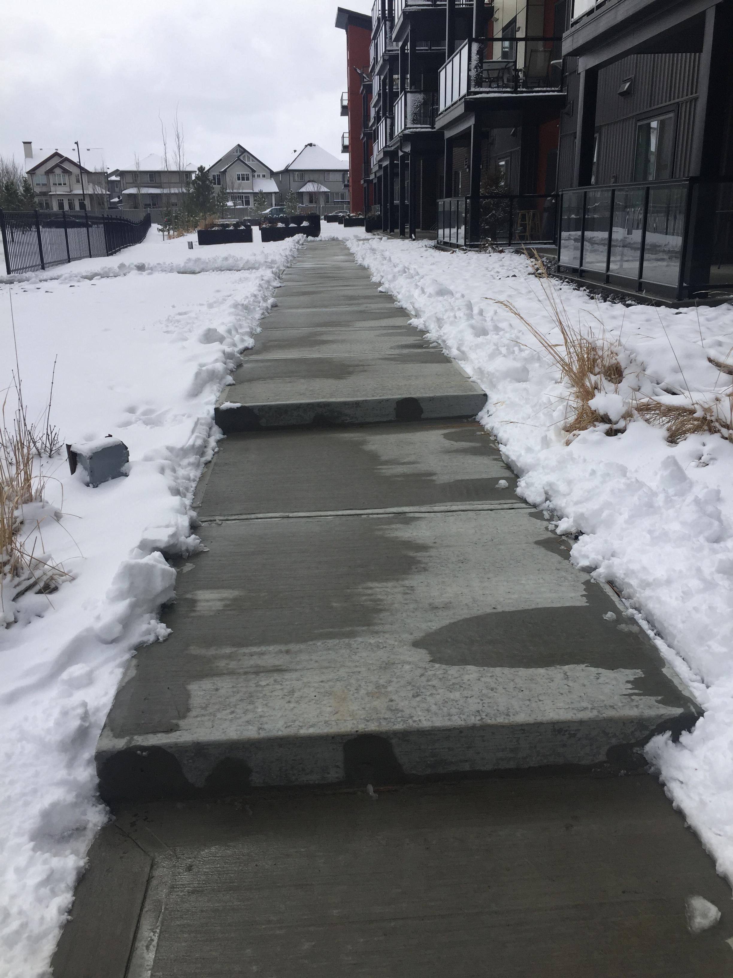 Commercial sidewalk steps cleared beside apartment building entrance
